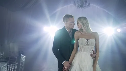 Elegant Couple Holding Hands in Dramatic Event Lighting Stock Footage 337136848