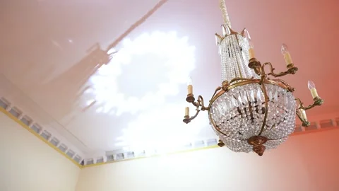 Elegant Crystal Chandelier Casting Light Patterns on Ornate Ceiling Interior Stock Footage 338166249