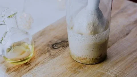 Elegant culinary presentation: mixing spices into creamy walnut sauce Stock Photos