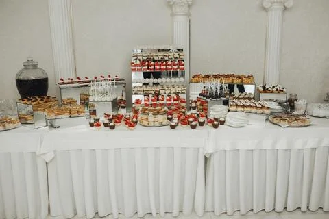 Elegant dessert table draped in white linen Foto stock