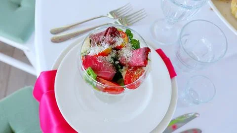 Elegant dining setup displaying fresh salad with sliced beef, tomatoes, grated Stock Photos
