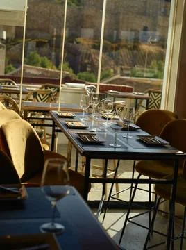 Elegant dining setup with empty wine glasses on table in a restaurant with... Stock Photos