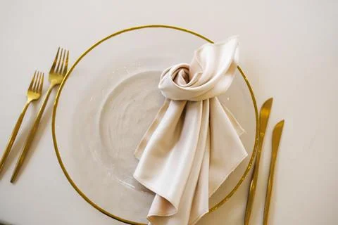 Elegant dining setup featuring a clear plate with a golden rim, adorned with a Stock Photos