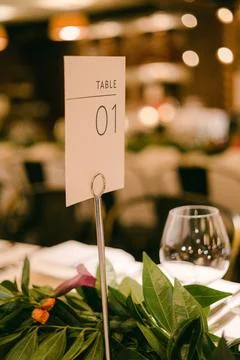 Elegant dining setup with table 01 sign in warmly lit restaurant during evening Stock Photos