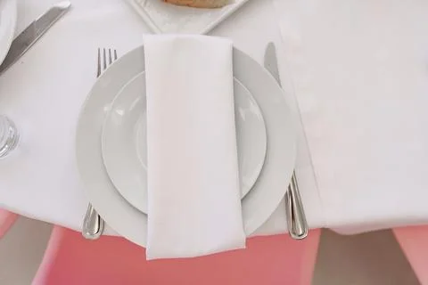 Elegant dining setup with white tableware and napkin Stock Photos