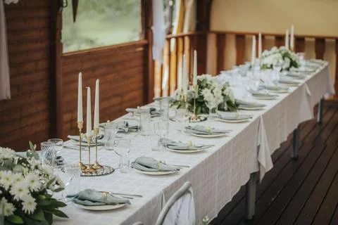 Elegant dining table set for a formal event with white tablecloth, floral c.. Stock Photos