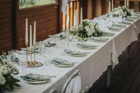Elegant dining table set for a formal event with white tablecloth, floral c.. Stock Photos