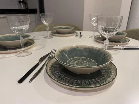 Elegant dining table set with plates, bowls, and glassware for a formal din.. Fotos de archivo