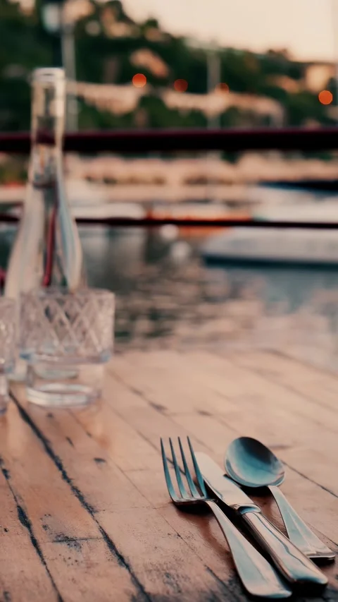 Elegant dining table set with silverware and glass water bottle at sunset w.. Stock Footage 339373333