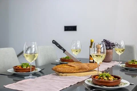 Elegant dining table set with white wine, artisan bread, and gourmet salad .. Stock Photos