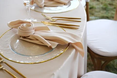 Elegant dining table setting featuring fine china plates, golden cutlery, and Photos