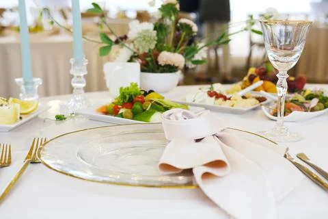 Elegant dining table setting with fine glassware, decorative plates, fresh Stock Photos