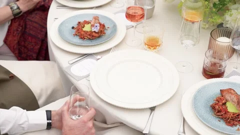 Elegant Dining Table Setting with Gourmet Plated Food and Drinks at Formal Event Stock Footage 338165677