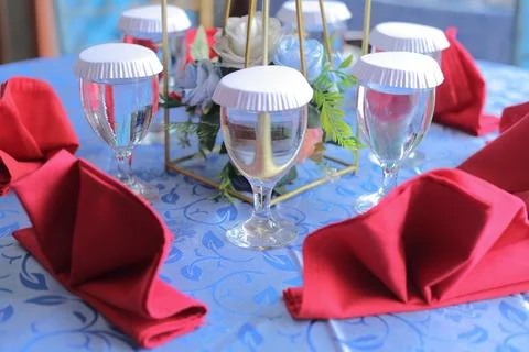 Elegant dining table setting with red napkins and floral decor Фото
