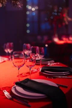 Elegant dining table setting with red tablecloth, glassware, and festive de.. Stock Photos