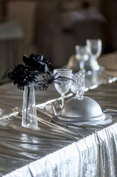 Elegant dining table setting with silverware and decorative flower arrangemen Stock Photos