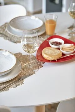 Elegant dining table setting with wine glasses, plates, and a tray with bre.. Stock Photos