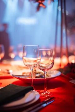 Elegant dining table setting with wine glasses and delicious food  Stock Photos