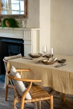 Elegant Dining Table Setting with Wishbone Chairs and Linen Tablecloth Stock Photos