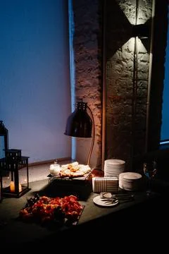 Elegant dining table setup with delicious food, warm lighting, and cozy Stock Photos