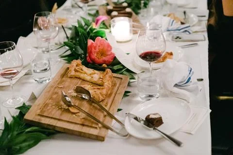 Elegant dinner setting featuring dessert and wine at a beautifully arranged Foto stock