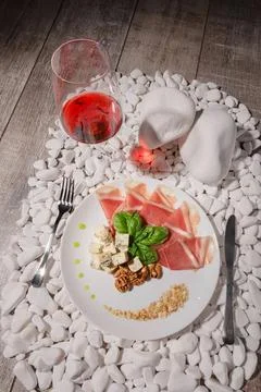 Elegant dinner setting with wine, cheese, and fruit on a pink table Stock Photos