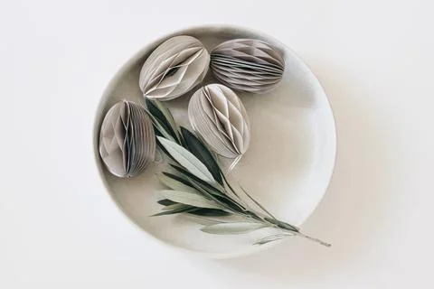 Elegant Easter decoration. Spring still life scene. Plate of egg shaped folded Foto stock