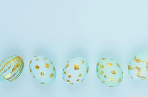 Elegant easter eggs with gold design as border on blue background, copy space Stock Photos