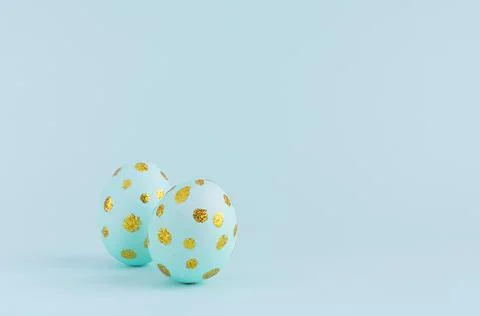 Elegant easter eggs with gold dots on blue background, copy space. Stock Photos