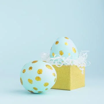 Elegant easter eggs with gold dots and golden gift box on blue background, sq Stock Photos