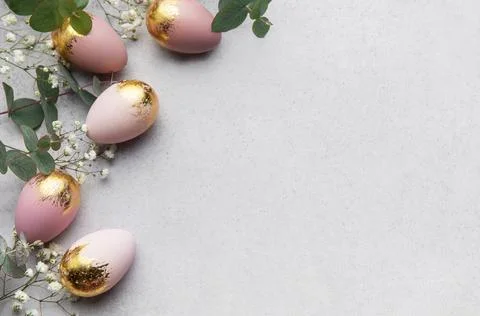 Elegant easter eggs with gold leaf and eucalyptus leaves creating a border .. Stock-Fotos