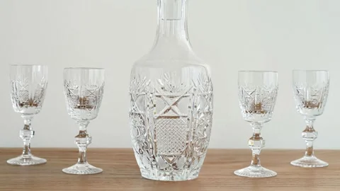 Elegant empty bottle and small crystal glasses with high stem on the table Stock Footage 287916356