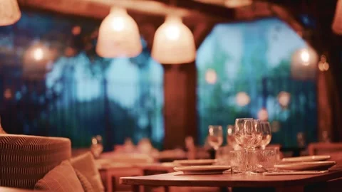 Elegant empty restaurant dining room at dusk with warm glowing lights and s.. Stock Footage 339117896