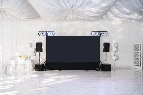 Elegant event space with a large screen and decorative lighting setup Stock Photos
