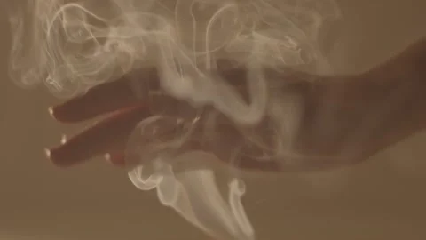 Elegant female hand gently stroking warm vapor fume shining in natural sunlight Stock Footage 144362753