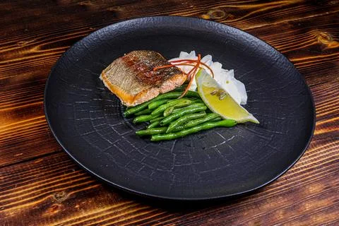 Elegant Fish Steak with Mash and Green Beans on Black Plate - Side View Stock Photos