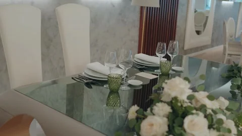 Elegant glass dining table with formal place setting and floral centerpiece Stock Footage 328956197
