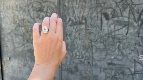 Elegant hand with oval diamond ring against stone wall Video stock 319694028