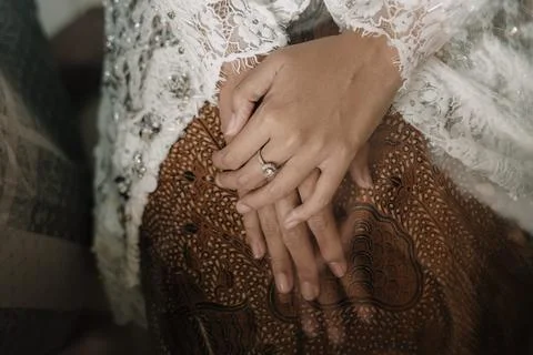 Elegant hands with ring on patterned fabric Фото