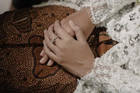 Elegant hands with ring on patterned fabric Stock Photos