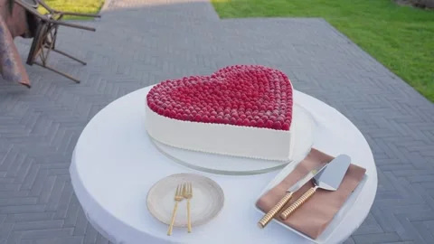 Elegant Heart-Shaped Raspberry Cake Outdoors on White Table for Celebration Stock Footage 336399392