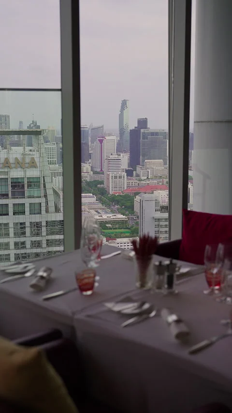 Elegant High-Rise Restaurant Table Setting with Panoramic View of Bangkok City Stock Footage 336220134