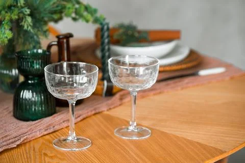 Elegant holiday table setting with empty glasses and evergreen Christmas de.. Stock Photos