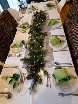 An Elegant Holiday Table Setting featuring Green Accents alongside Charming Stock Photos