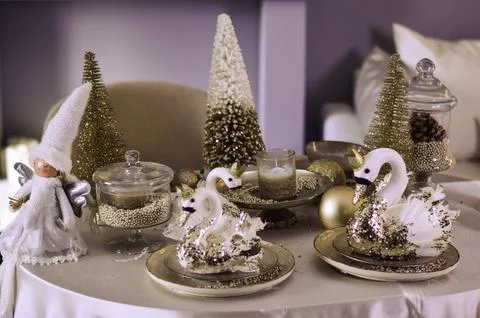 Elegant holiday table setting featuring decorative swans, sparkling trees, .. Stock Photos