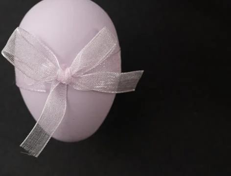 An Elegant Lavender Easter Egg adorned with a Beautiful Bow, perfect for fe.. Stock Photos