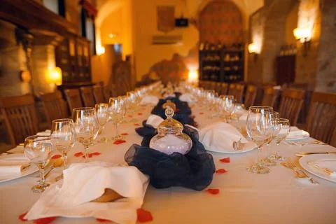 Elegant long dining table set for a formal banquet with rose petals and cry.. 写真素材