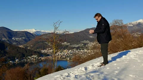Elegant Man Making and Throwing a Snow Ball and Joy Mountain View Stockbeeldmateriaal 191953798