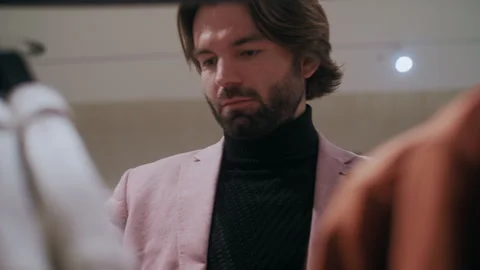 Elegant Man in Pink Jacket Browsing Clothing Racks Vidéo 311888883