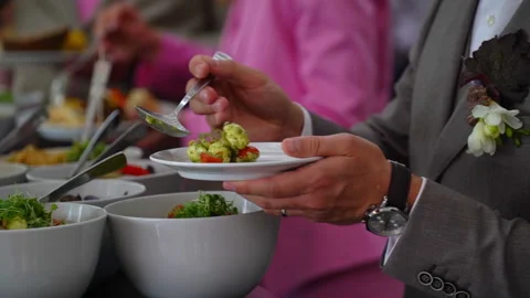 Elegant man serving salad at a wedding buffet. Stock Footage 294979700